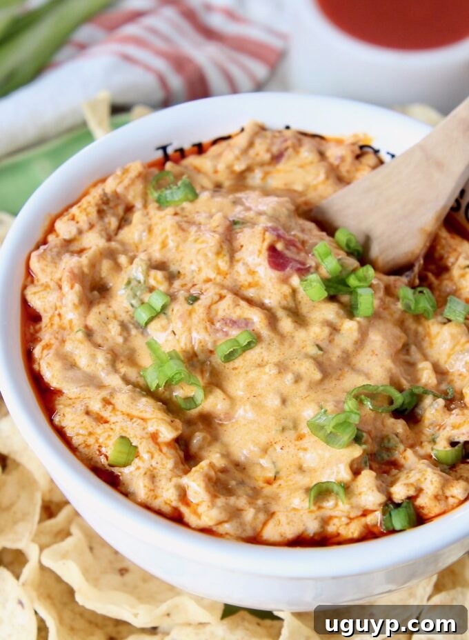 Creamy cheeseburger queso dip in a bowl with a spoon, ready to be served