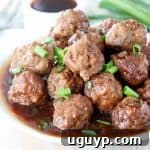 Korean BBQ Meatballs on plate with korean bbq sauce and diced green onions