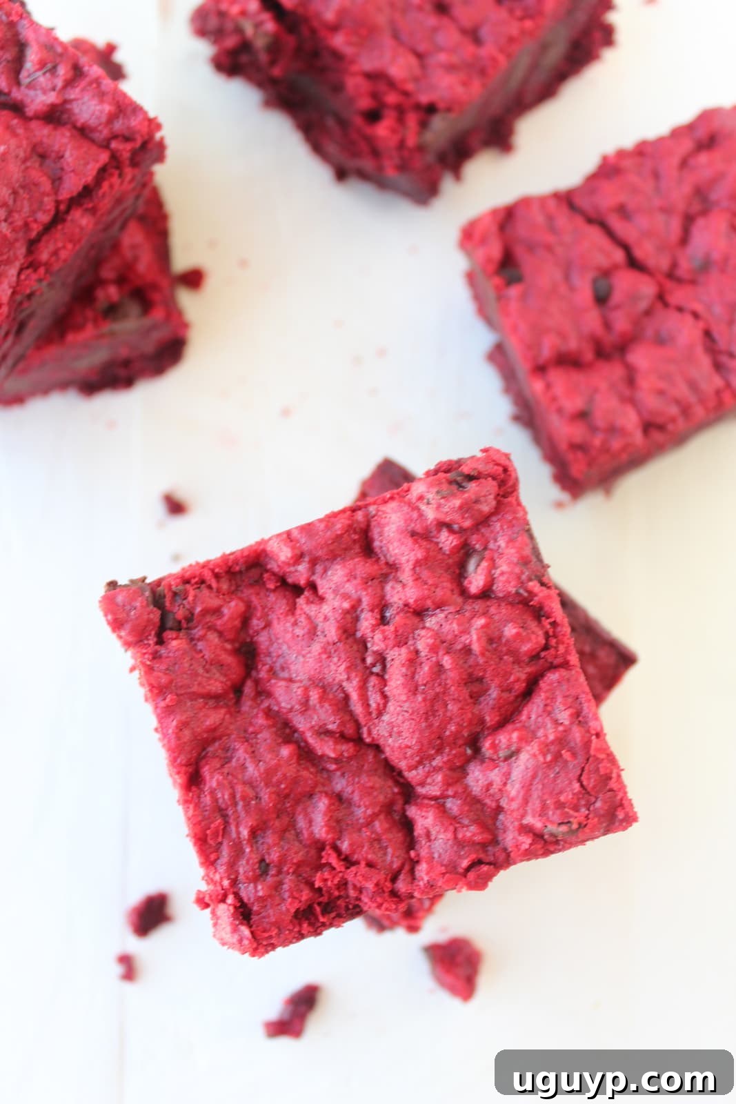 Several Red Velvet Brookies stacked elegantly on a white surface, showcasing their delicious layers and deep red color.