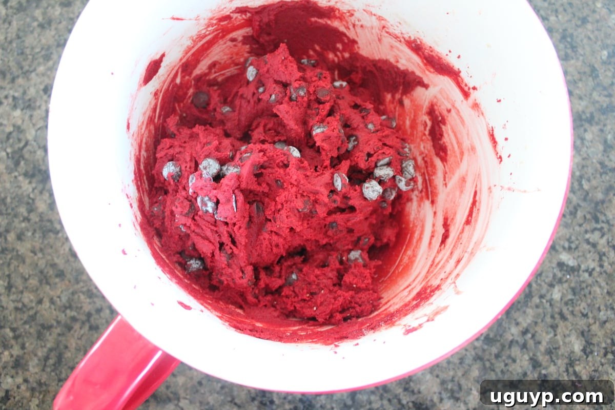 Red velvet chocolate chip cookie dough mixed in a bowl, ready for chilling.