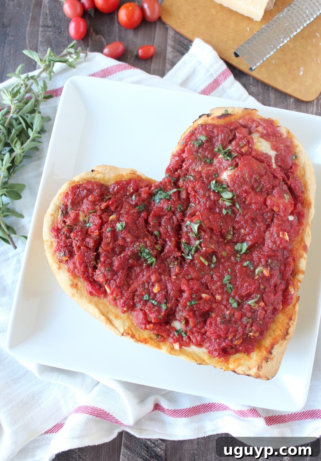 A slice of heart shaped deep dish pizza being pulled from the pan.