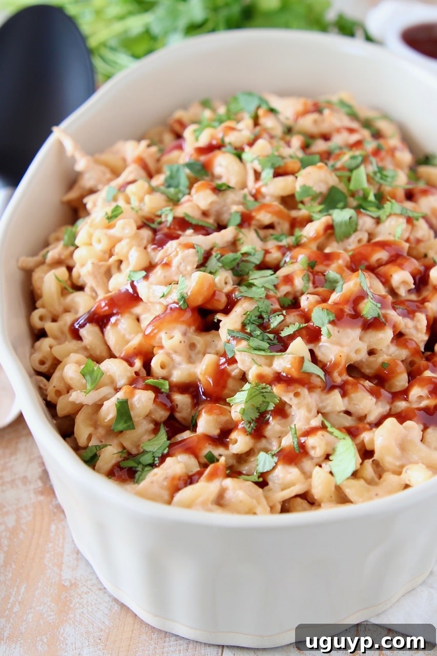 Mac and cheese topped with bbq sauce and cilantro in large oval baking dish
