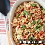 Mac and cheese topped with bbq sauce and cilantro in oval casserole dish