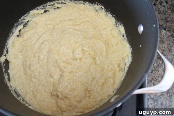 Creamy prepared polenta cooking in a large pot on the stove