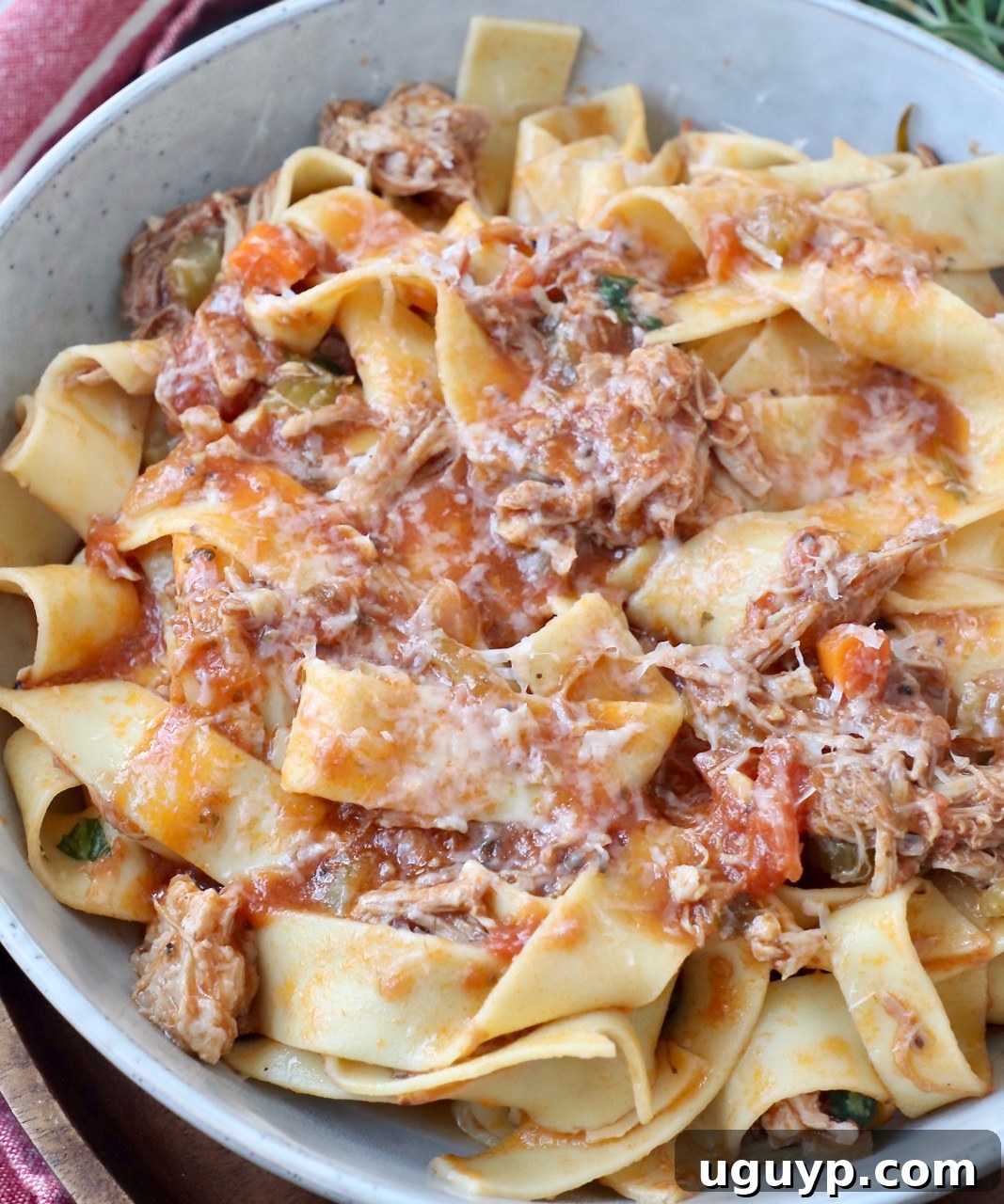 cooked pasta tossed with pork ragu sauce in a bowl