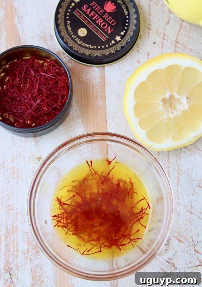 Saffron threads soaking in fresh lemon juice in a small white bowl, preparing to release their vibrant color and flavor into the paella.