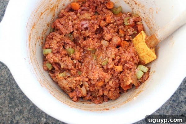 buffalo chicken meatloaf mixture in large mixing bowl with spatula