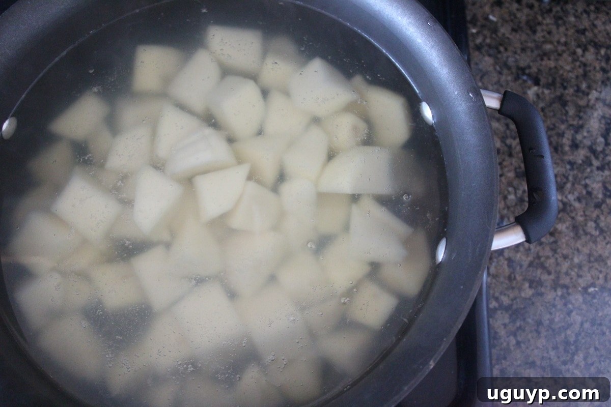 Buffalo Blue Cheese Mashed Potato Recipe - Cubed potatoes boiling in a large pot on the stove.