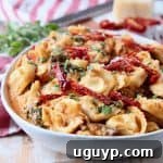 Vegetarian tortellini in white bowl with sun dried tomatoes, mushrooms and basil