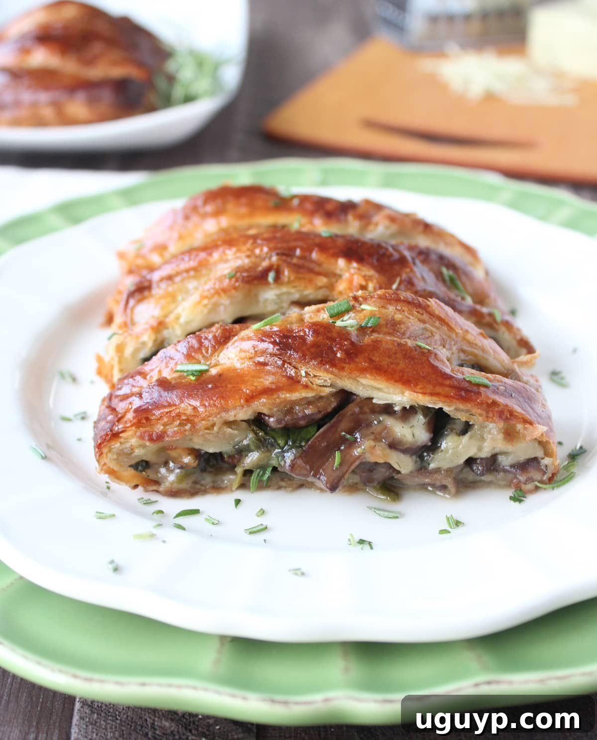 Slices of mushroom spinach puff pastry arranged on a plate, showing the rich filling.