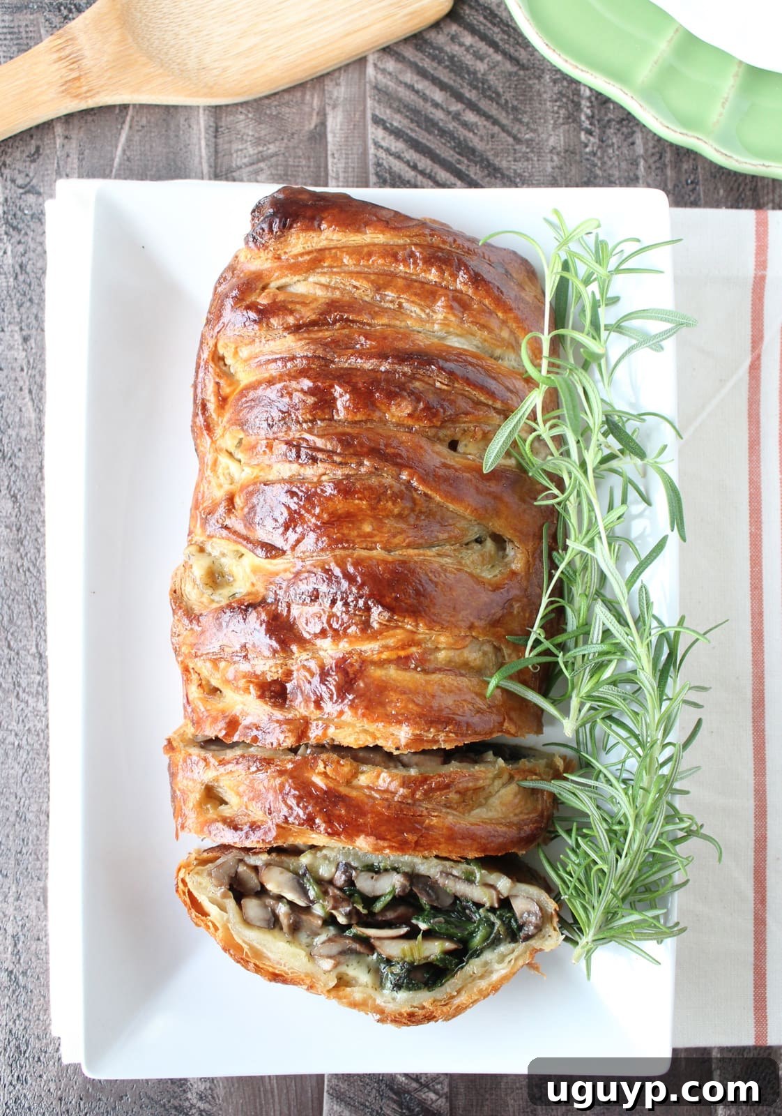 Close-up of a baked puff pastry filled with mushrooms and spinach, showcasing the flaky crust and savory interior.