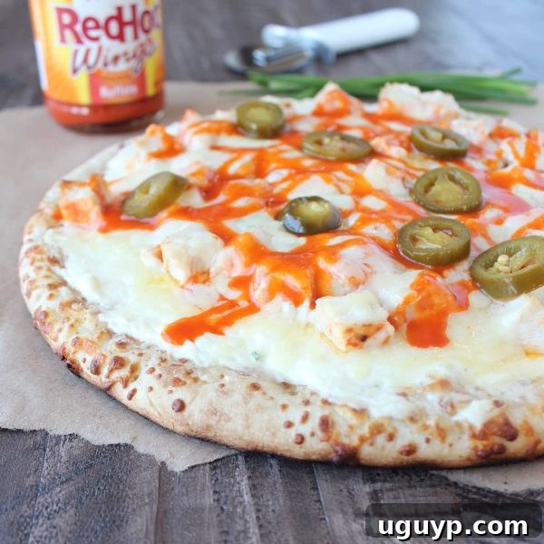 Delicious Buffalo Chicken Dip Pizza topped with melted cheese, spicy buffalo chicken, and fresh jalapeño slices.