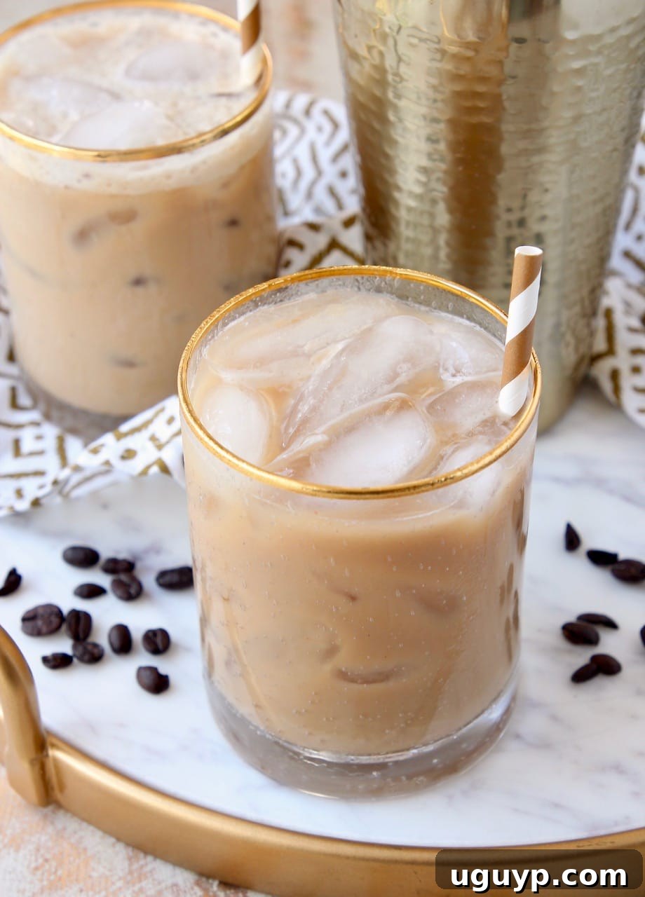 Two glasses of Long Island Iced Coffee cocktails on a elegant marble and gold serving tray, ready to be enjoyed.