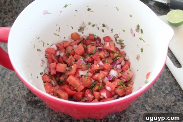 Tossing the watermelon salsa ingredients to combine flavors.