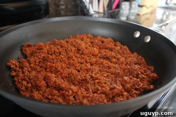 Cooking chorizo in a skillet until browned and cooked through.