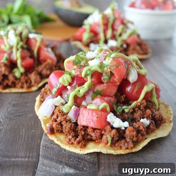 Assembled Chorizo Tostadas with Watermelon Salsa and Avocado Cream Sauce.
