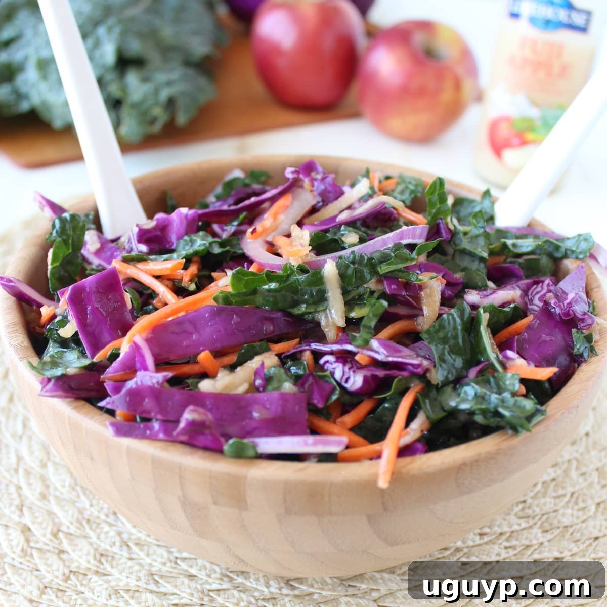 Freshly prepared Kale Apple Slaw in a rustic wooden bowl, ready to be served at a summer gathering or meal.