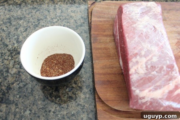 uncooked brisket on wood board, sitting next to a bowl of mixed spices
