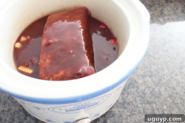 brisket in a crock pot covered in bbq sauce
