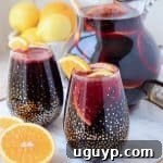 Red sangria in glasses and pitcher with sliced oranges