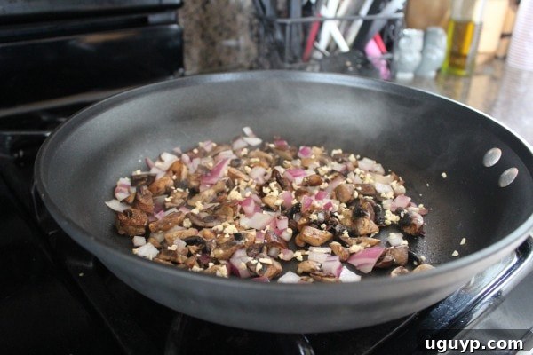 Ground turkey, onions, and mushrooms cooking in a skillet, seasoned with Italian herbs