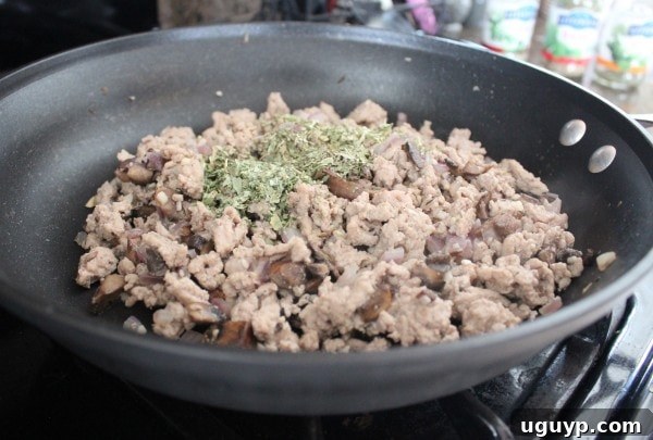 Ground turkey and vegetables simmering in a skillet with Italian seasoning