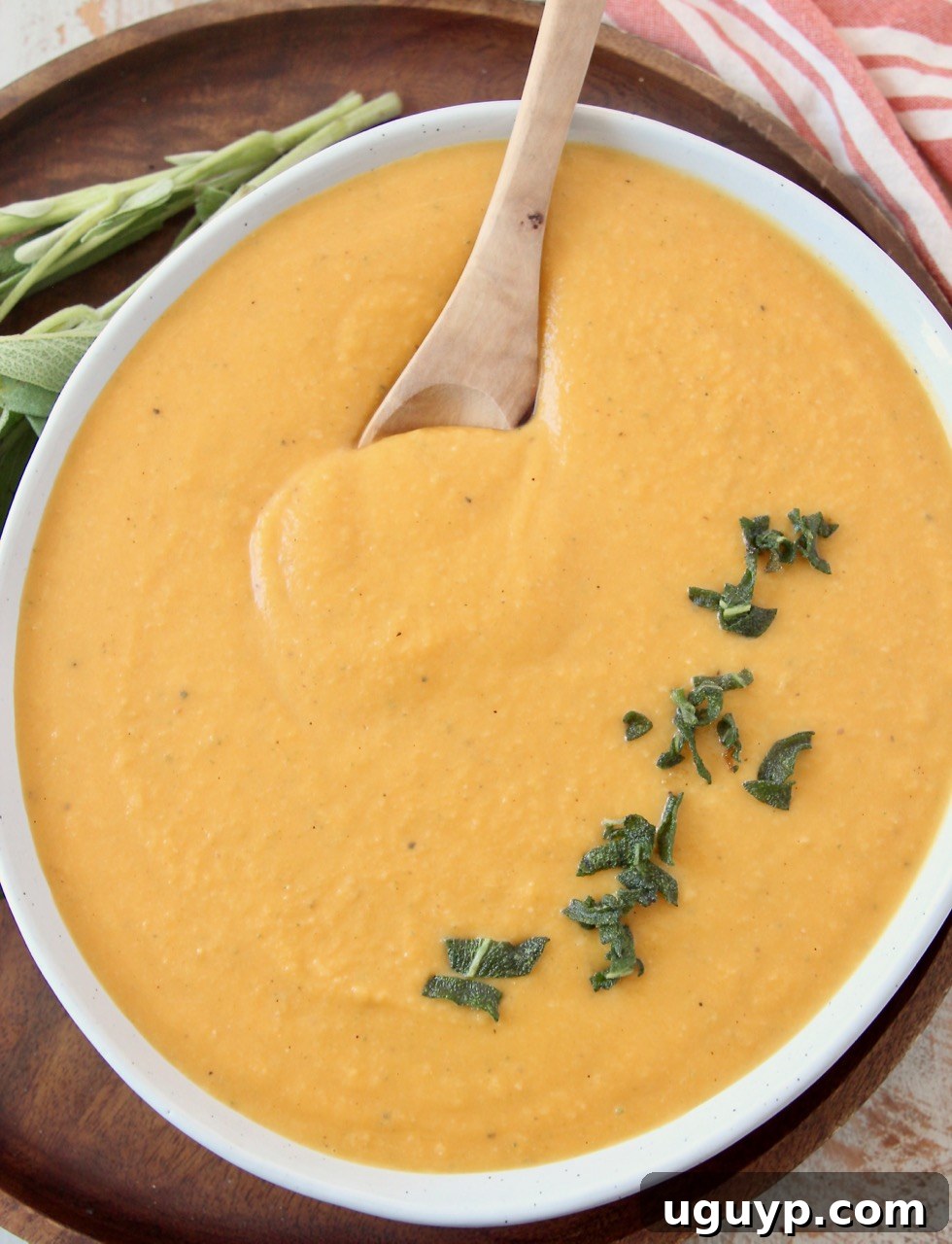 Butternut squash pasta with fresh sage in a white bowl with a spoon, ready to be enjoyed.