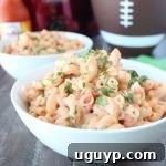 A bowl of creamy Buffalo Crock Pot Mac and Cheese with a fork.