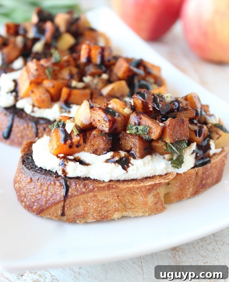 Plated Butternut Squash Apple Bruschetta, featuring perfectly diced roasted squash and apples over ricotta on toasted bread, artfully drizzled with balsamic glaze, prepared for serving.