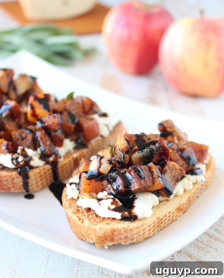A single piece of butternut squash apple bruschetta on a white plate, showcasing the vibrant colors of the roasted vegetables, creamy ricotta, and the dark balsamic drizzle.