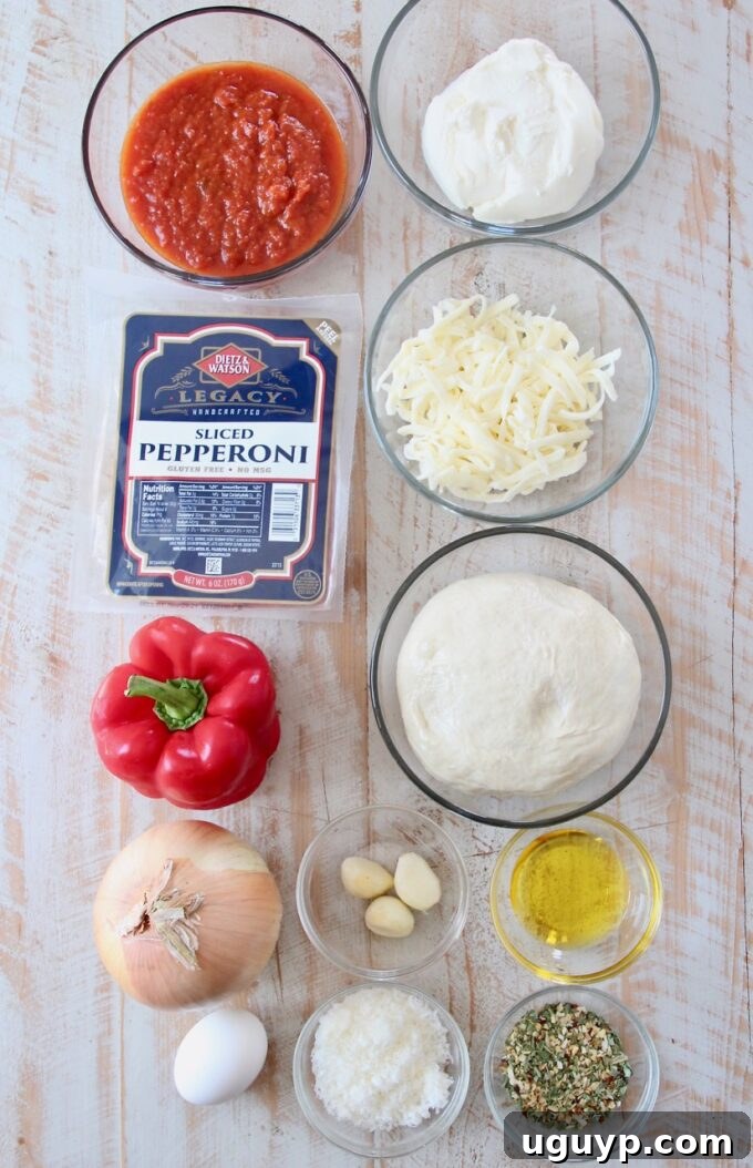 A collection of fresh ingredients neatly arranged, including pizza dough, bell peppers, onions, garlic, various cheeses, pepperoni, and Italian seasoning, ready for making calzones.