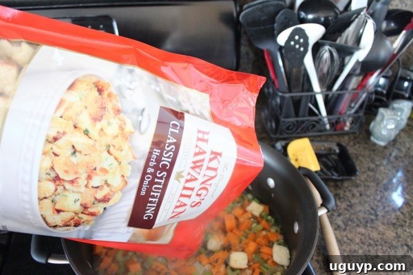 Mixing herb stuffing into sweet potato and vegetable base