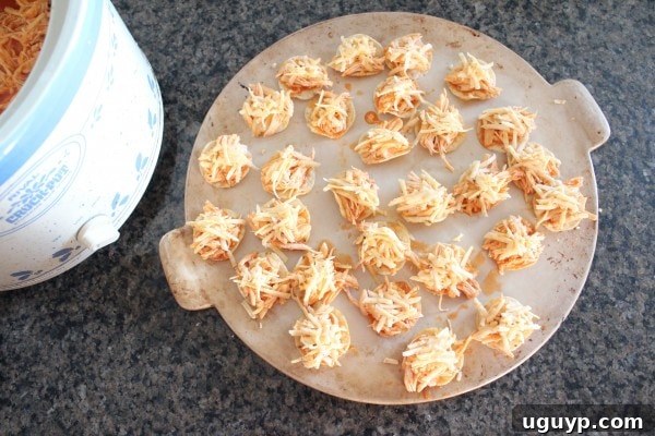Mini Buffalo Chicken Tostadas topped with shredded cheddar cheese