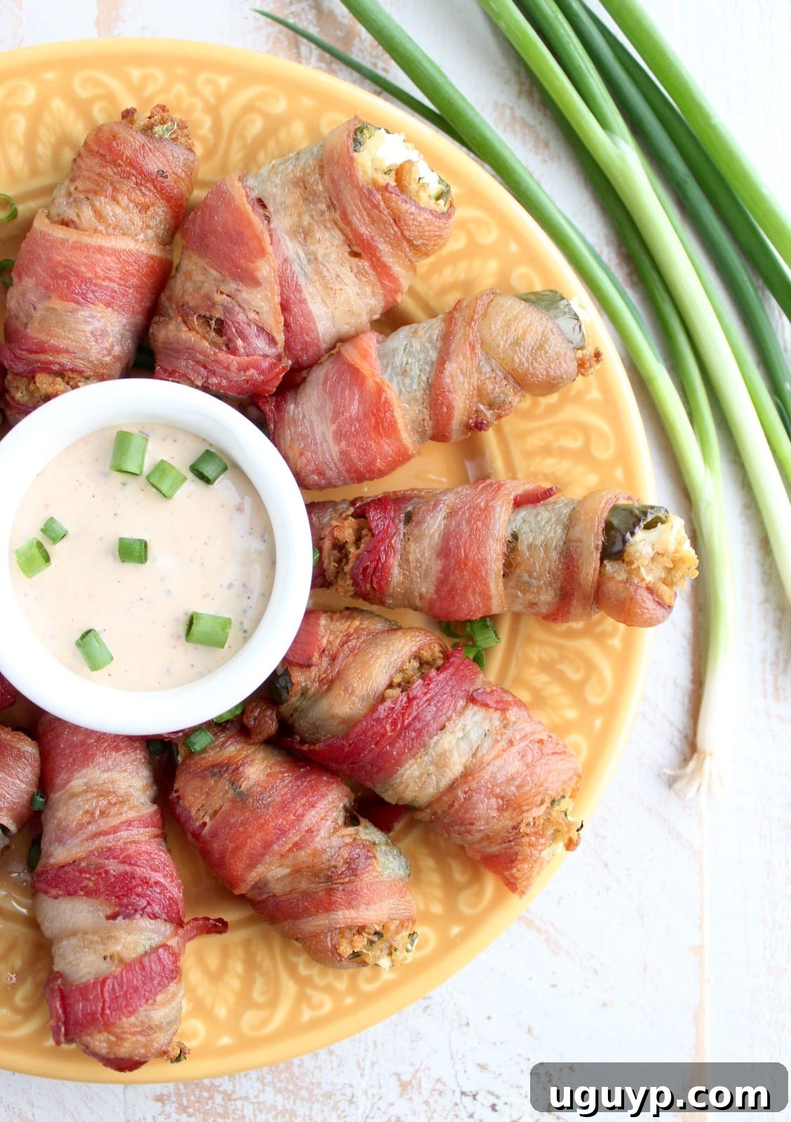 Close-up of Bacon Wrapped Stuffing Cream Cheese Jalapeno Poppers on a baking sheet before cooking