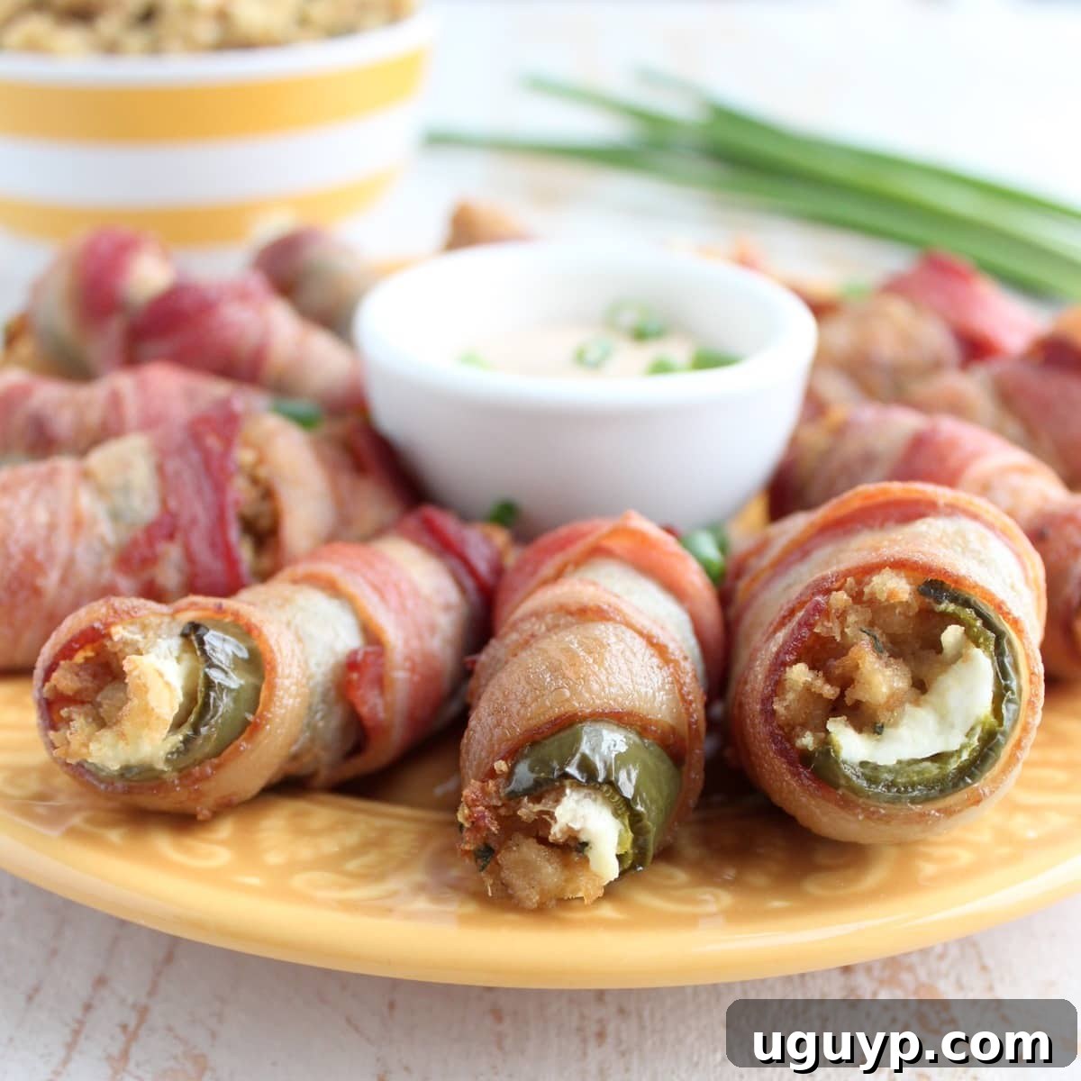 Platter of freshly baked Bacon Wrapped Stuffing Cream Cheese Jalapeno Poppers, garnished and ready to be served