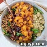 A beautifully presented bowl of roasted butternut squash salad with a fork, ready to be enjoyed.