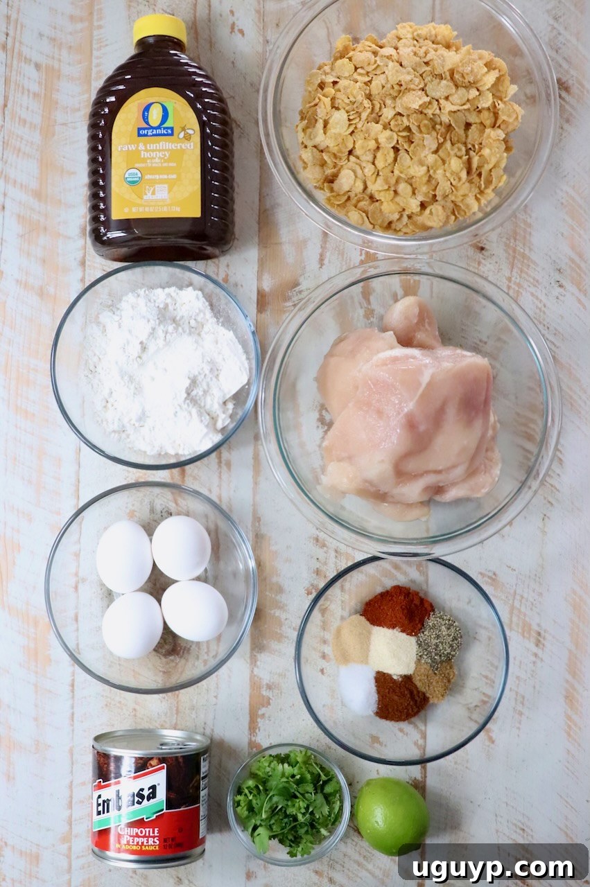 Ingredients for honey chipotle chicken crispers laid out on a white wooden board