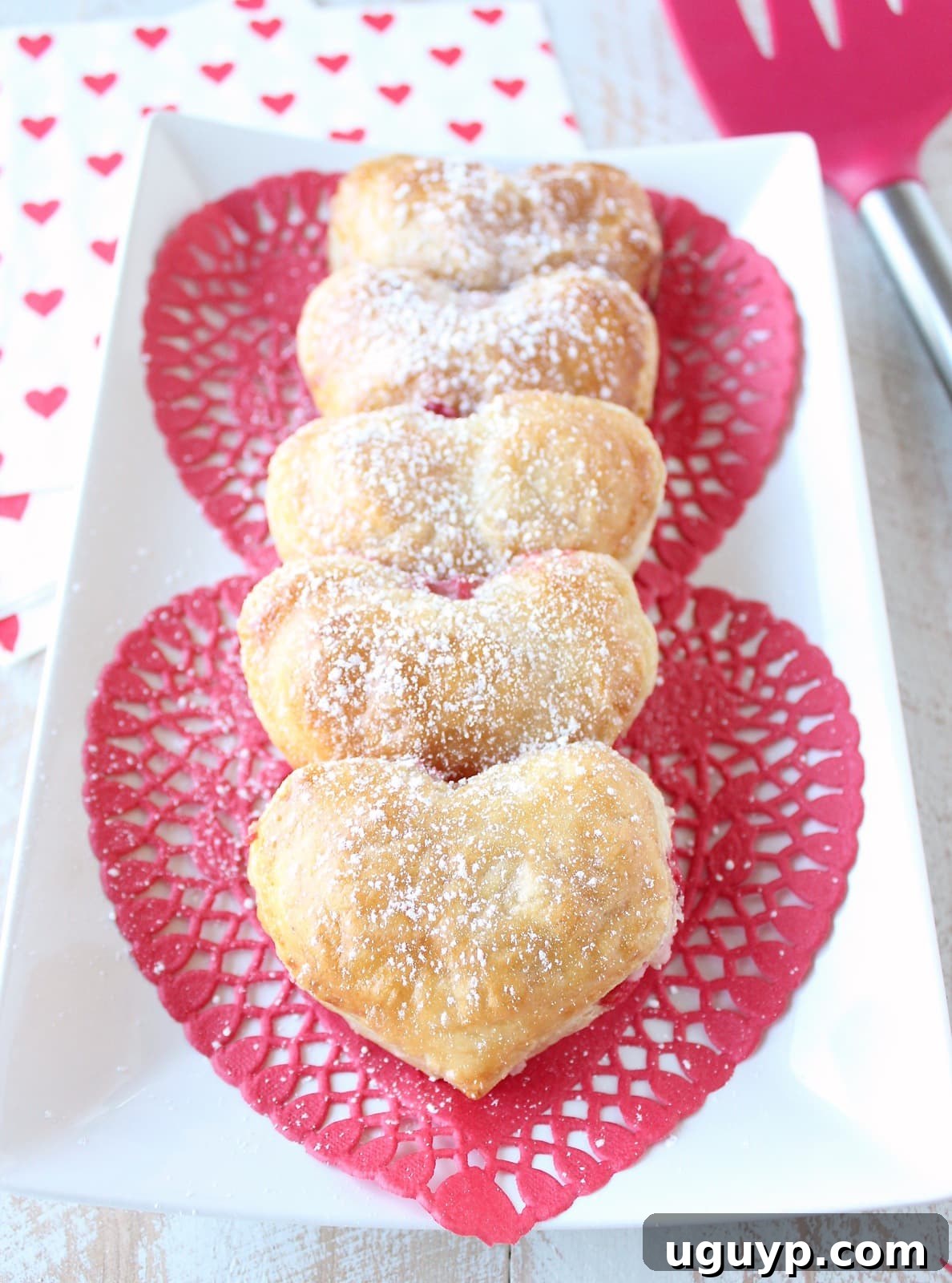 Freshly baked Heart Shaped Strawberry Cheesecake Puff Pastry Pies cooling on a rack