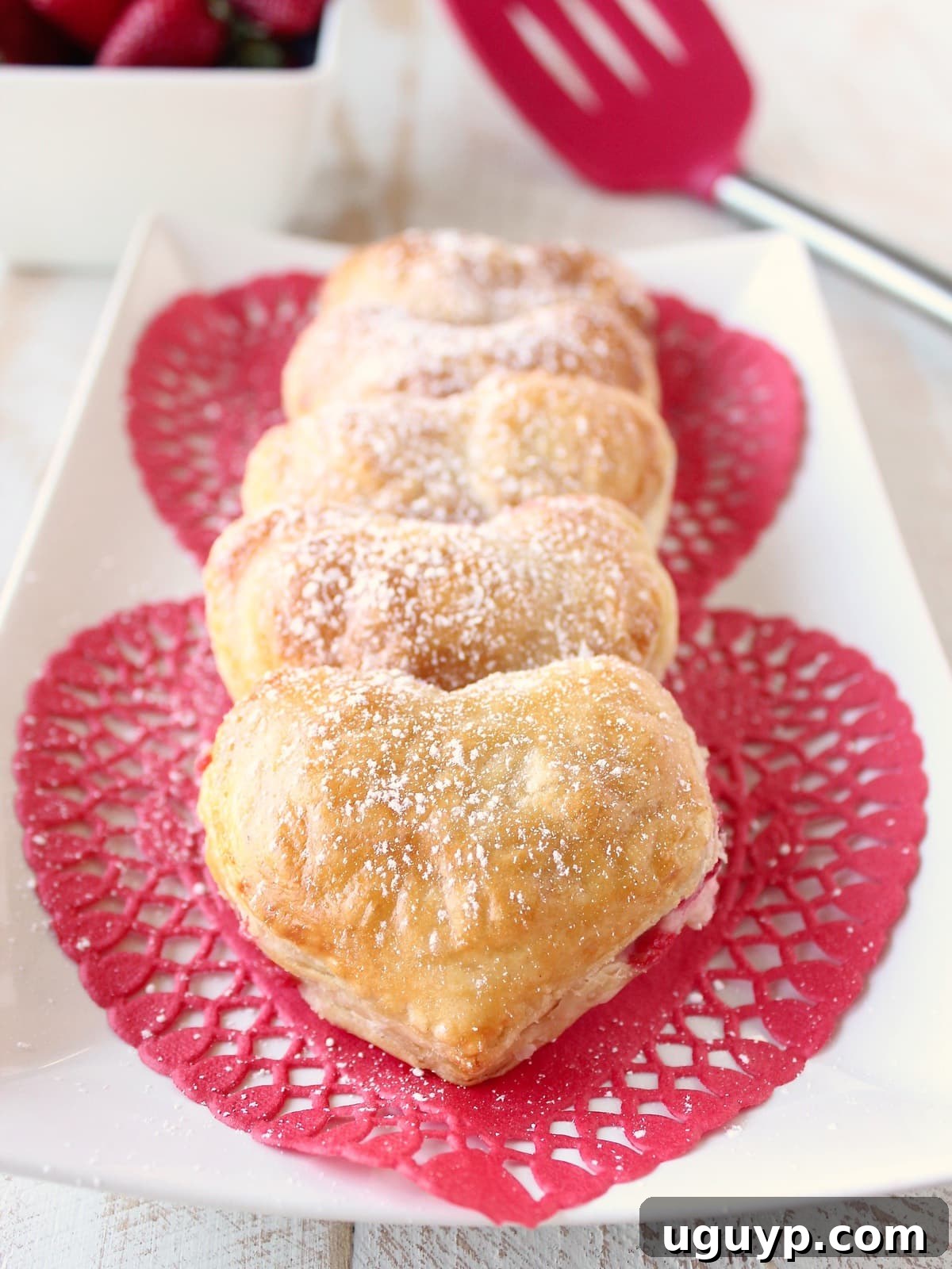 Close-up of a Heart Shaped Strawberry Cheesecake Puff Pastry Pie dusted with powdered sugar