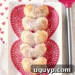 Strawberry cheesecake filling is wrapped up in heart shaped puff pastry dough in this mini strawberry cheesecake pie recipe, perfect for Valentine's Day!