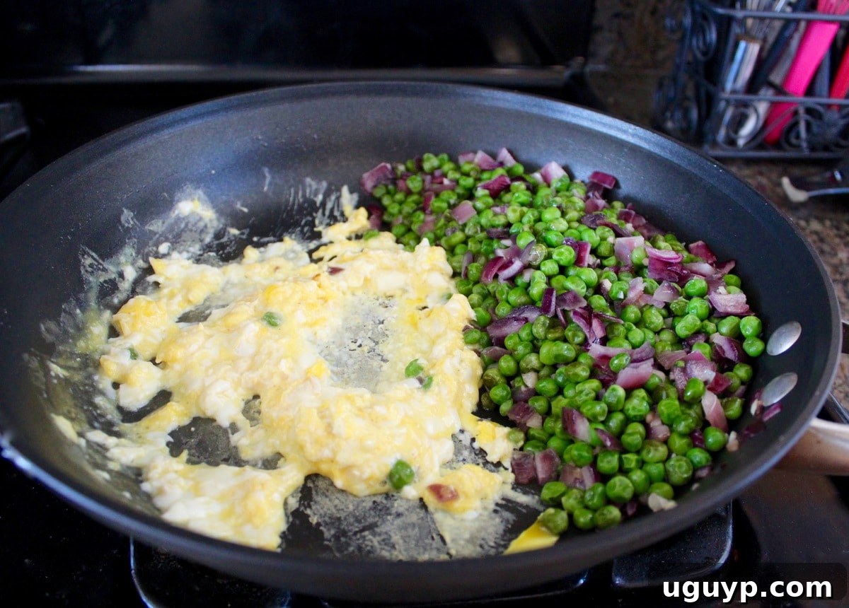 Close-up of vegetables and scrambled eggs cooking in a wok for fried rice