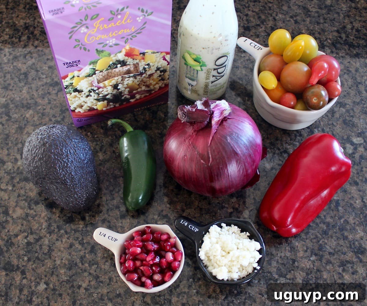 A beautiful arrangement of all the essential fresh ingredients for the Israeli couscous avocado salad, including vibrant bell peppers, red onions, a jalapeno, cherry tomatoes, and the creamy avocado, meticulously laid out on a polished granite countertop.