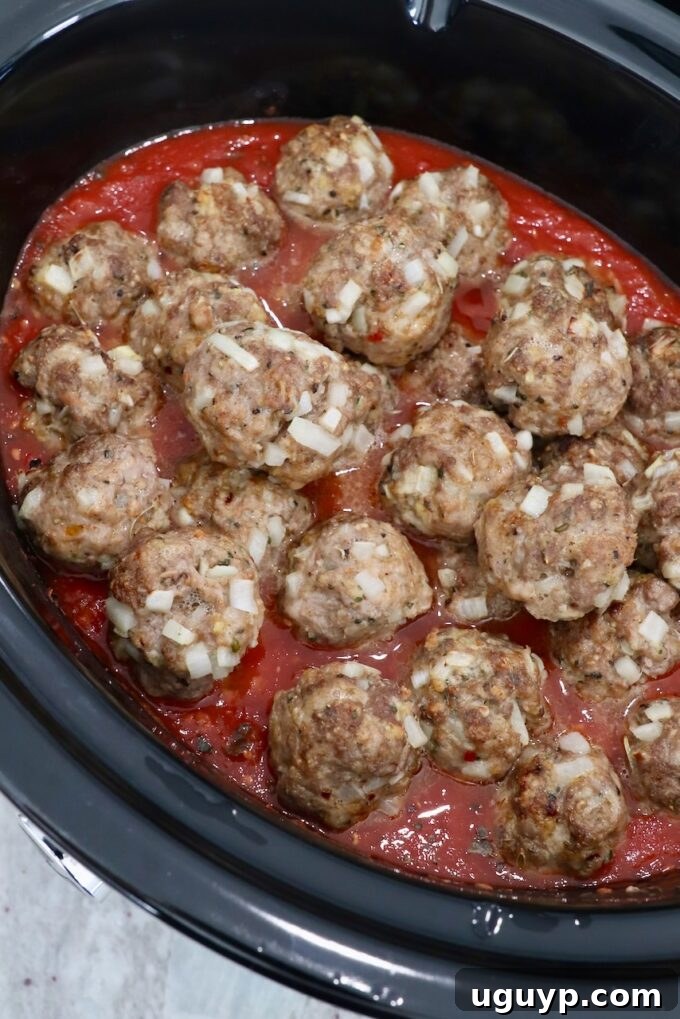 cooked meatballs in slow cooker with tomato sauce