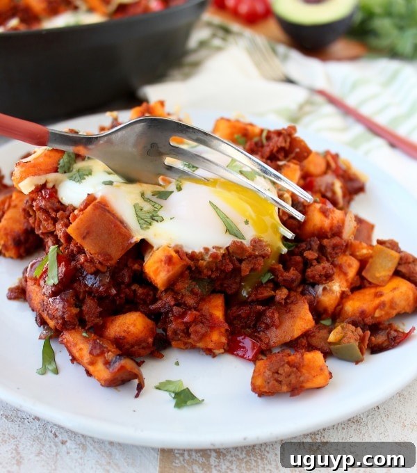 A close-up shot of Mexican Sweet Potato Hash with a perfectly cooked egg, ready to be enjoyed.