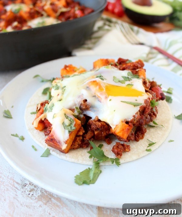 Delicious Mexican Sweet Potato Hash served in a skillet with fried eggs.