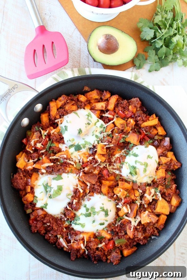 A large skillet of Mexican Sweet Potato Hash with cooked eggs and toppings, ready to serve.