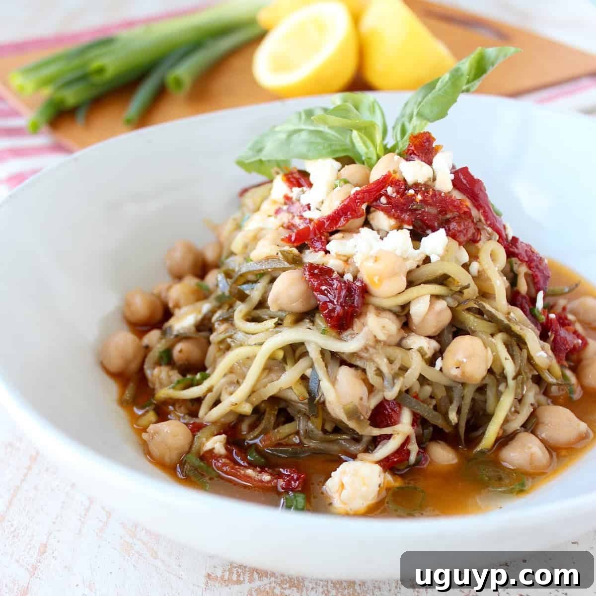 Greek Zucchini Noodles in a bowl topped with fresh basil leaves
