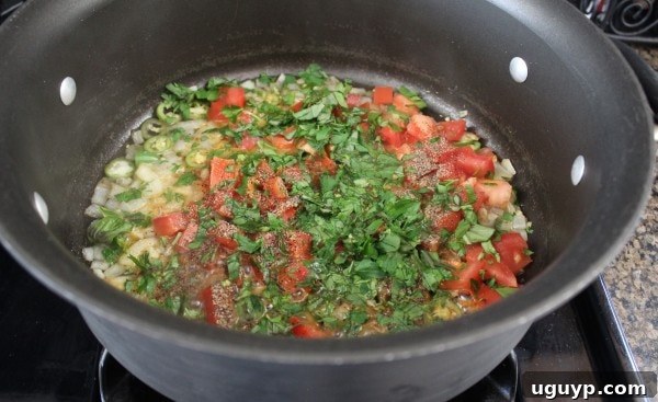 Adding tomatoes and herbs to the scampi sauce