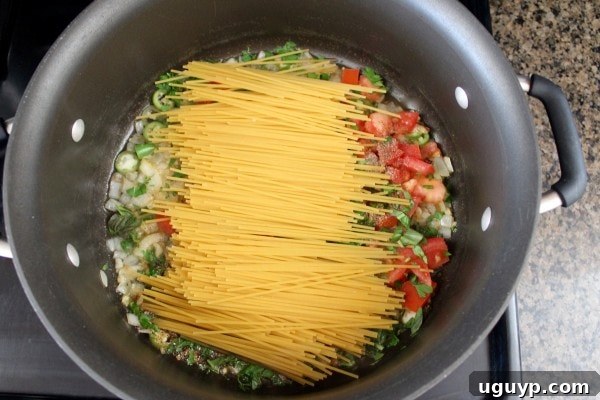Adding broken spaghetti noodles to the one pot meal