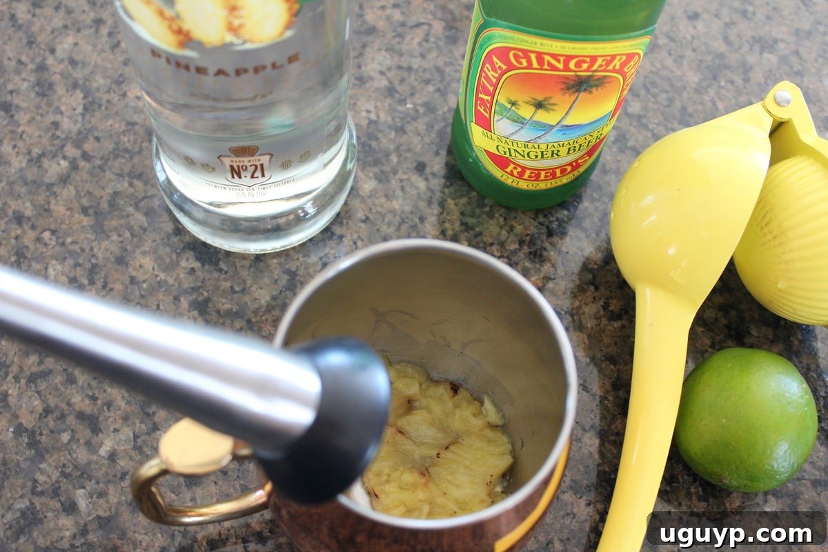 Muddling Grilled Pineapple in a Copper Mug for Moscow Mule